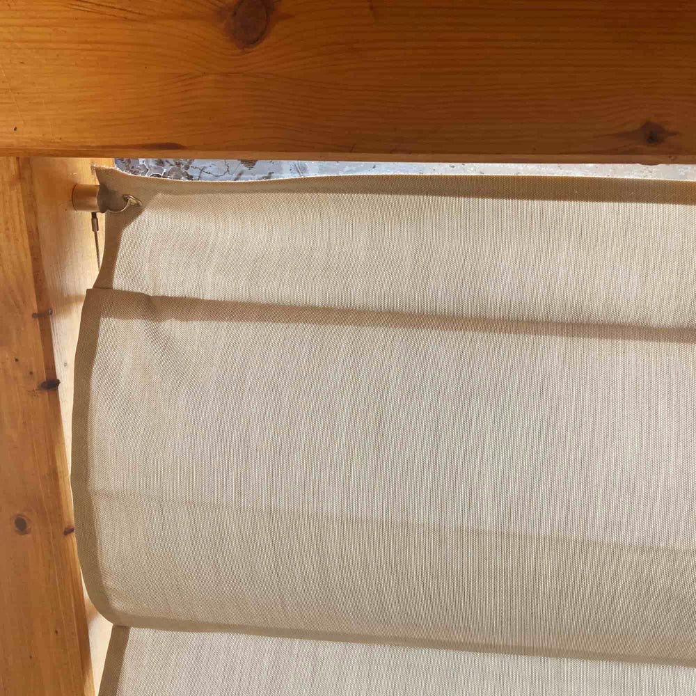 Made in GREEN-Textil in Grau in der Seilspannmarkise auf Maß zwischen den Sparren aus Holz im Terrassendach