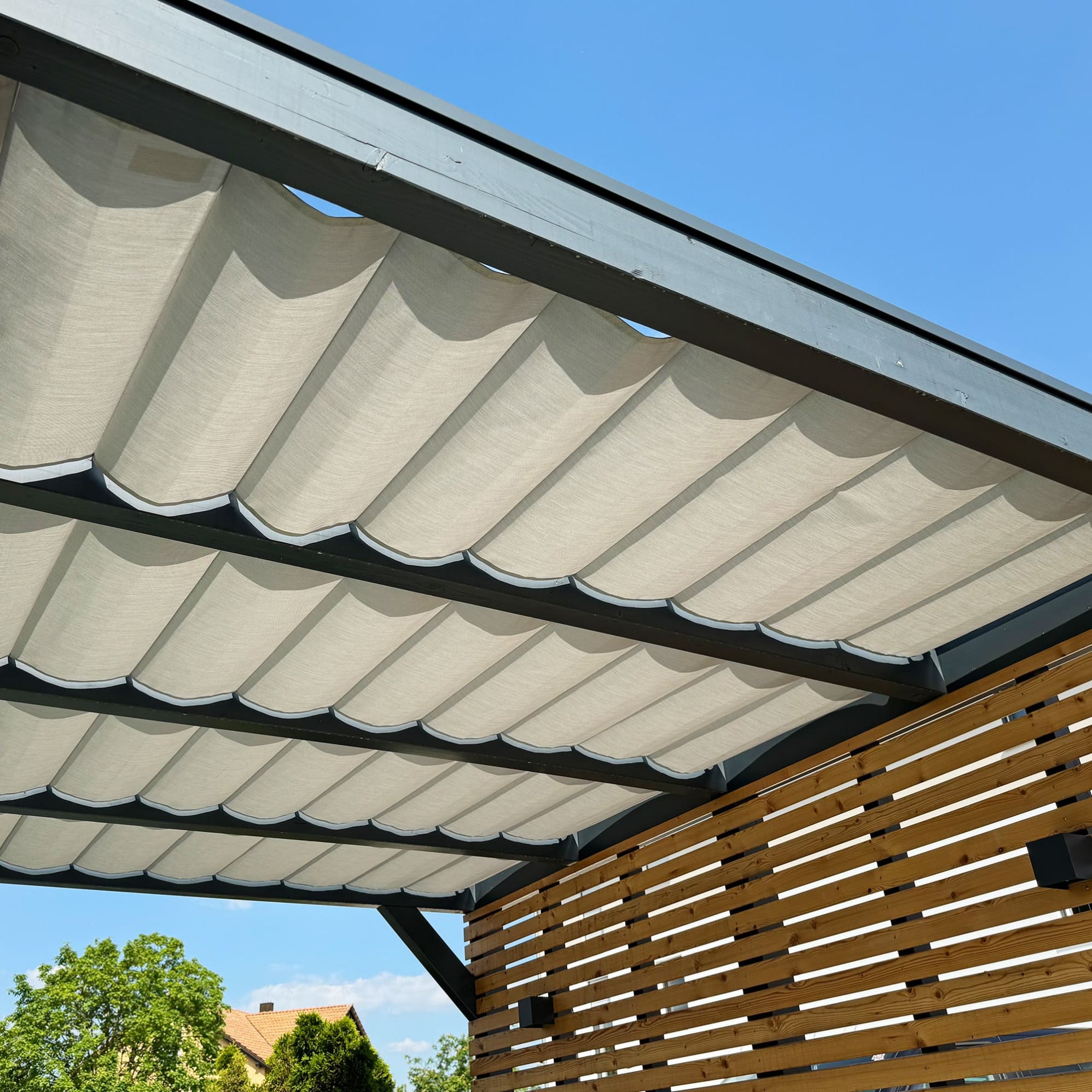 Alurohre die im Textil eingenäht werden verleihen der Beschattung und Sonnenschutz im Terrassendach ein grafisch ruhige Optik und verbessern die Funktion der Bedienbarkeit