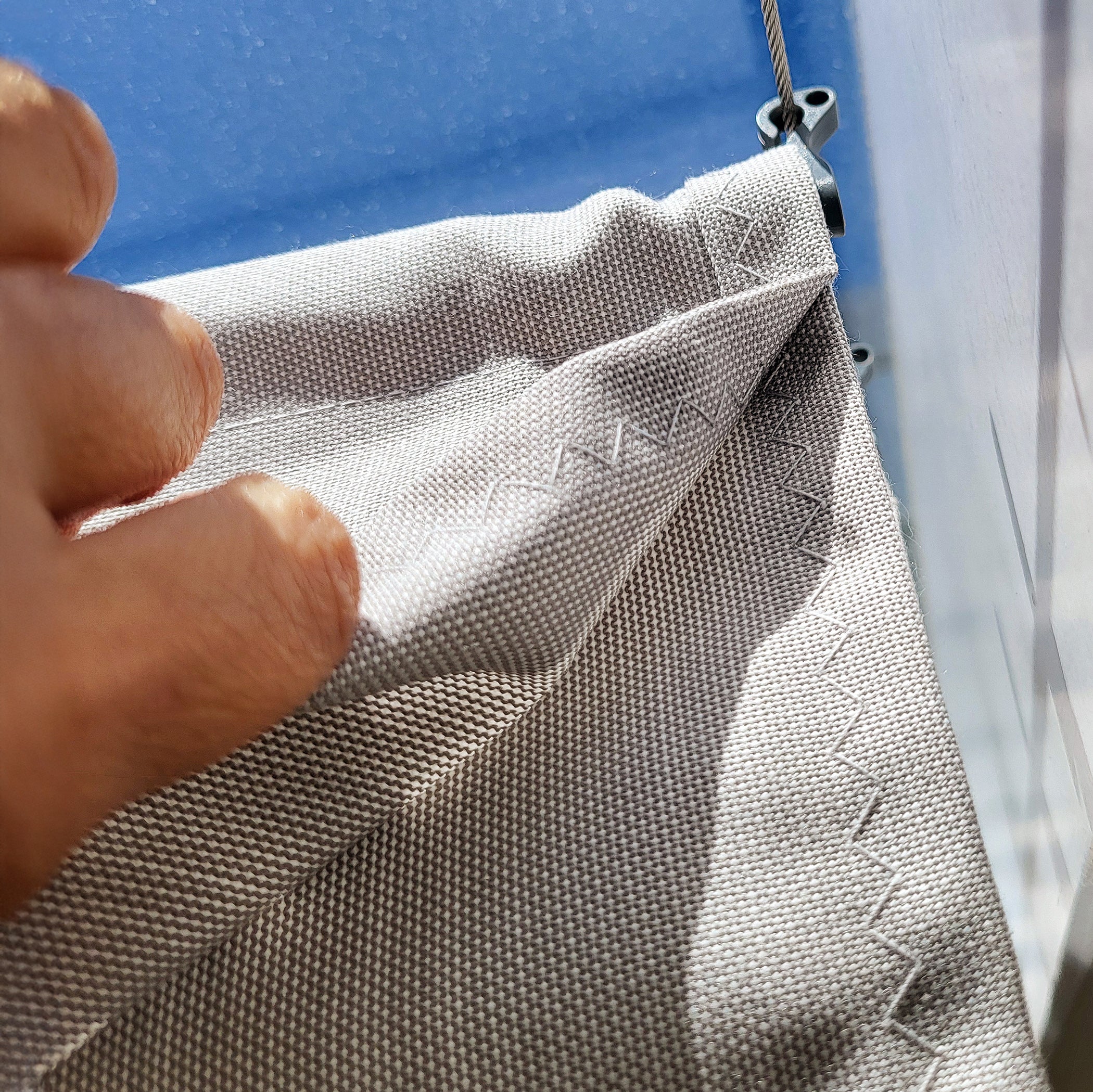 Zick-Zack-Naht an Wolkenbahn aus ACRYL ind Grau-Weiss unter Spannseil haengend am Pendelhaken